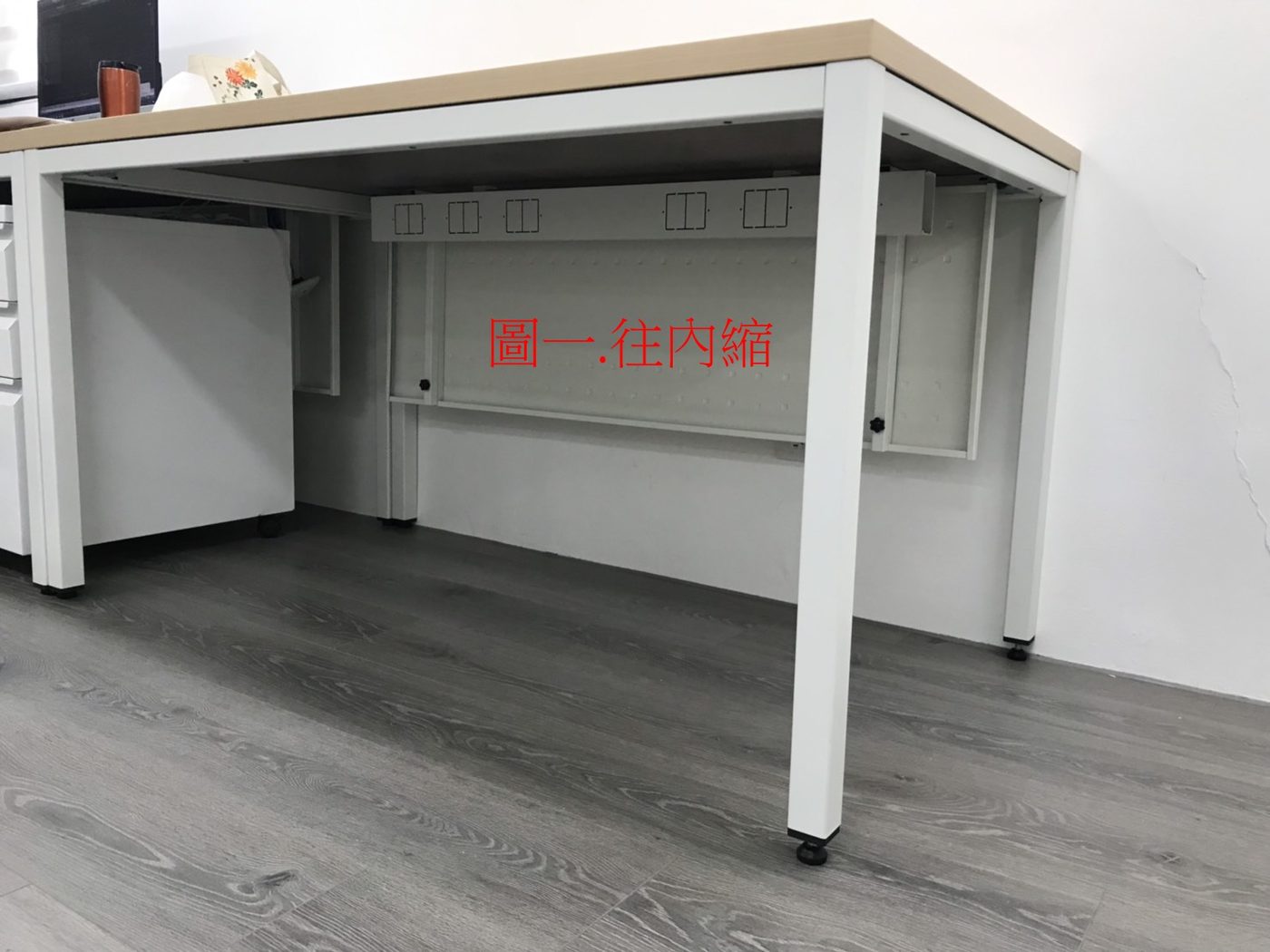 白腳工作桌桌下的白色檔板往內縮，紅字標示「圖一 往內縮」